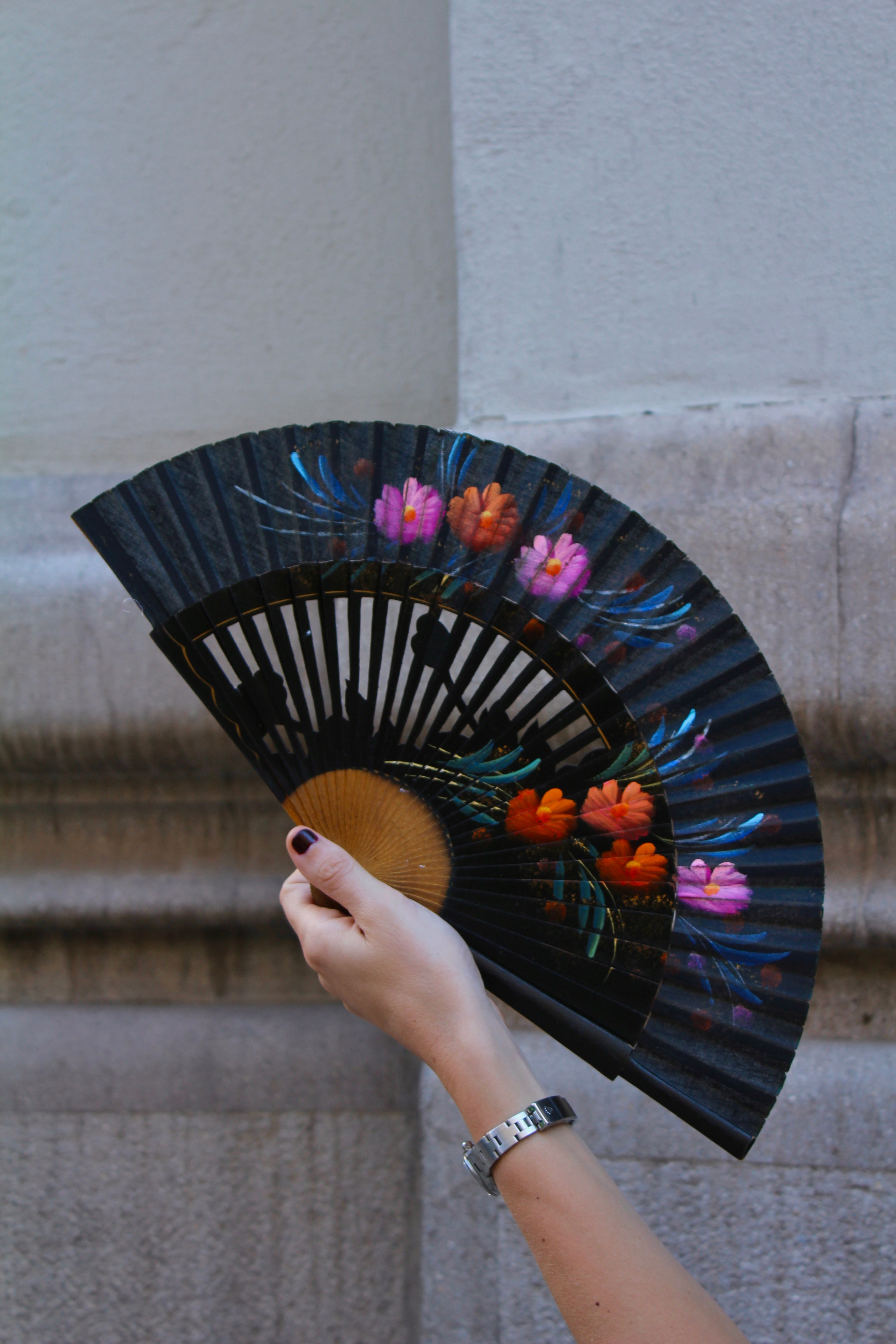 Abanico vintage español negro de madera pintado a mano con motivos florales en rosa, naranja y azul