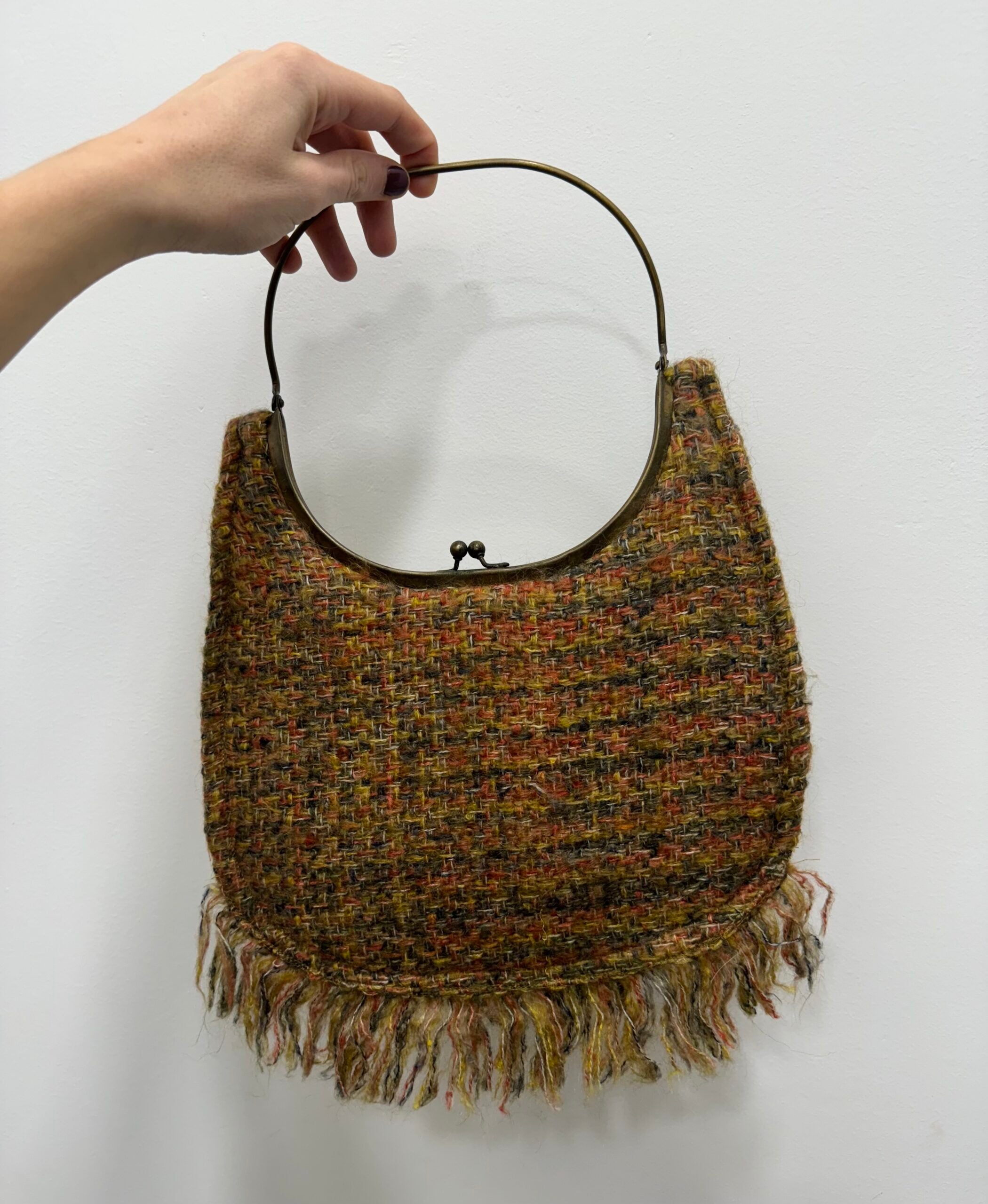 Bolsa vintage em lã com franjas claras.