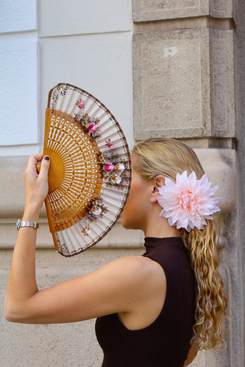 Abanico vintage español con varillas caladas de madera clara y tela cruda pintada a mano con motivos florales rosa, ocre, marrón y blanco